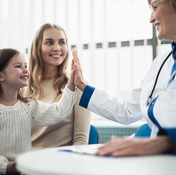 Doctor high-fiving child and mother.